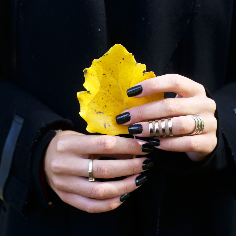 yellow-autumn-leaf-female-hands-with-black-manicure-stylish-rings